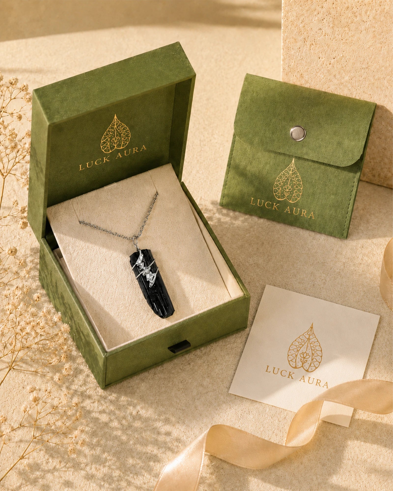Handmade black tourmaline soldered pendant necklace displayed with LuckAura gift packaging, dried flowers, and soft natural light as a meaningful jewelry gift.