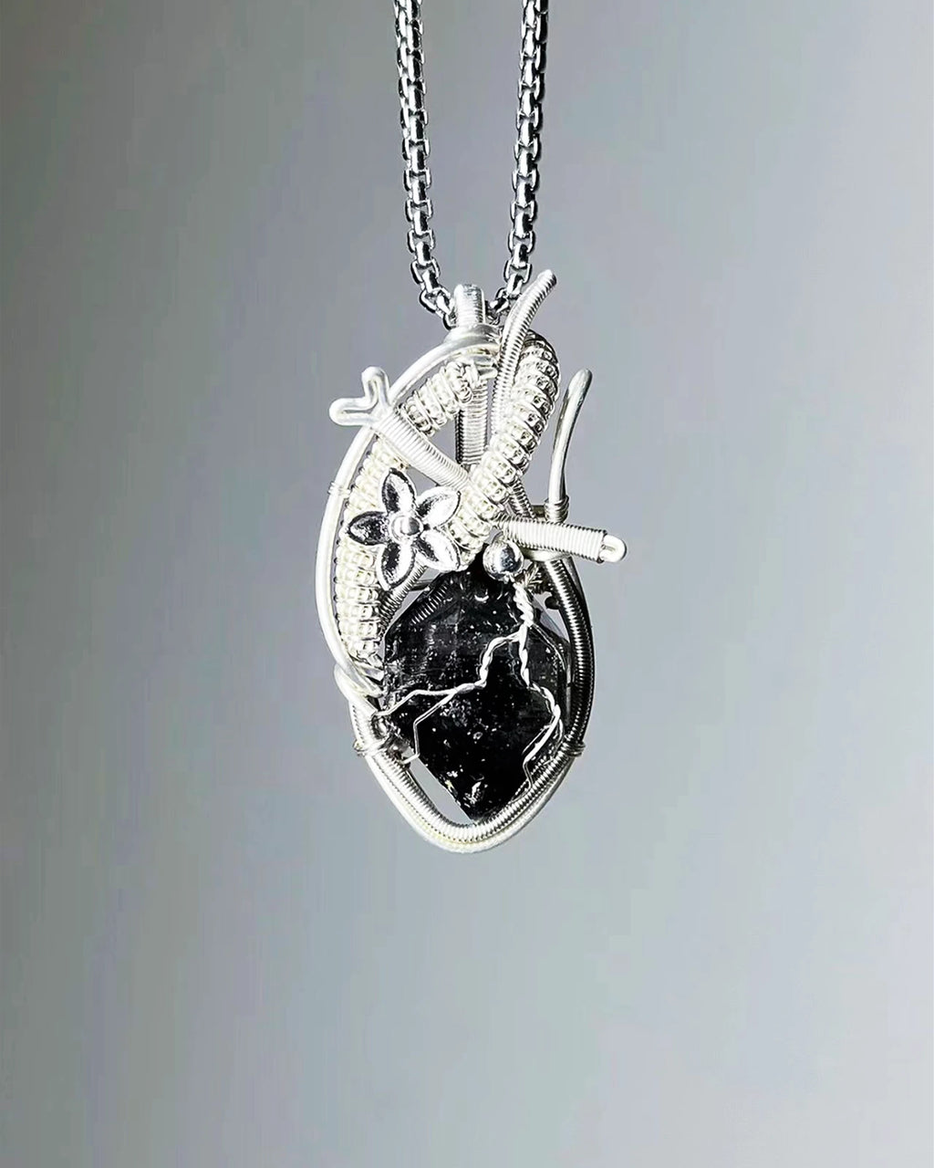 Handmade black phantom quartz crystal heart wire wrapped necklace with natural dark crystal pendant, symbolizing protection, grounding, and emotional strength.