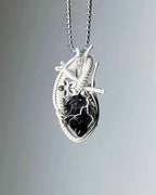 Handmade black phantom quartz crystal heart wire wrapped necklace with natural dark crystal pendant, symbolizing protection, grounding, and emotional strength.