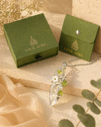 Handmade clear quartz garden wire wrapped necklace displayed with LuckAura gift packaging, dried flowers, and soft natural light as a meaningful jewelry gift.
