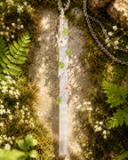 Selenite garden wire wrapped necklace styled in a calm natural setting with soft light, botanical details, and peaceful handmade crystal jewelry aesthetic.