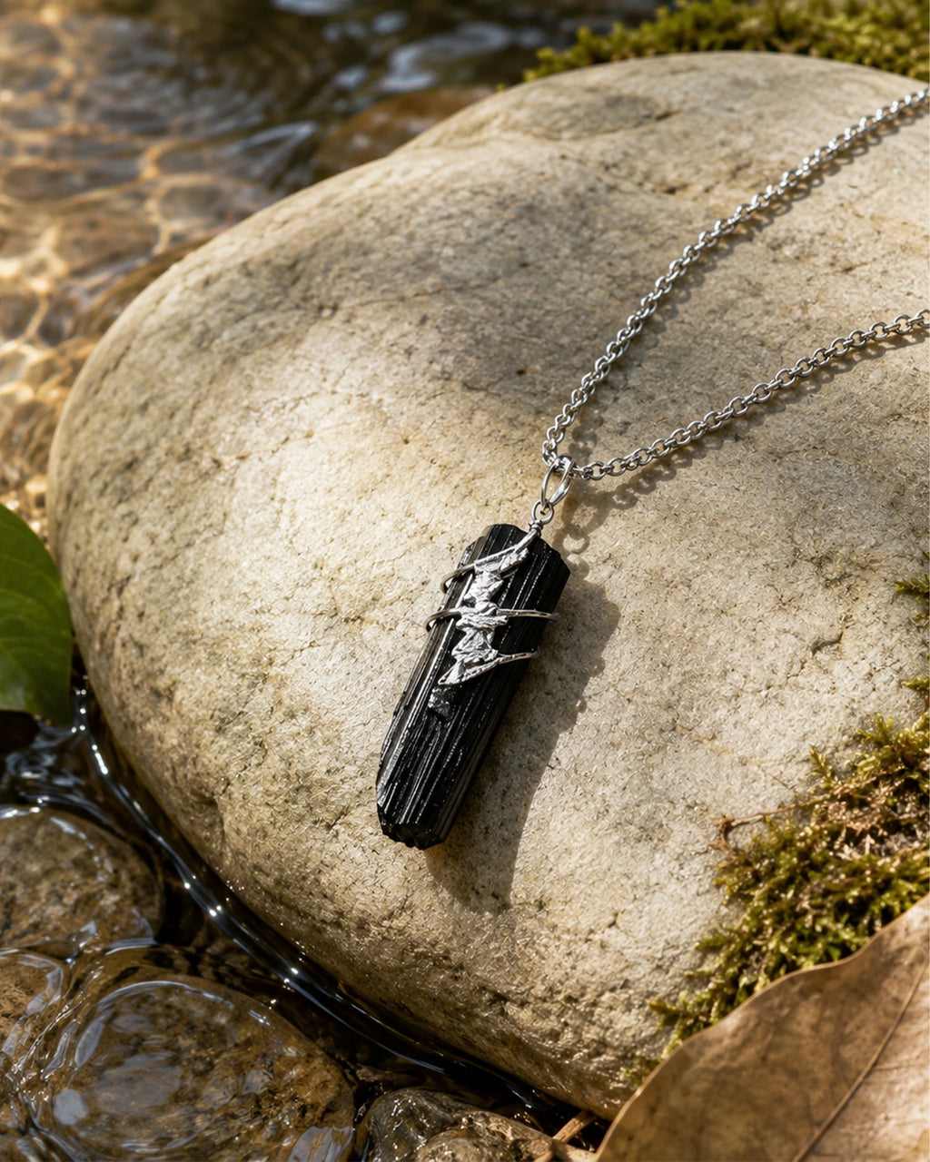 Black tourmaline soldered pendant necklace styled in a calm natural setting with stone, soft light, and a grounding handmade crystal jewelry aesthetic.