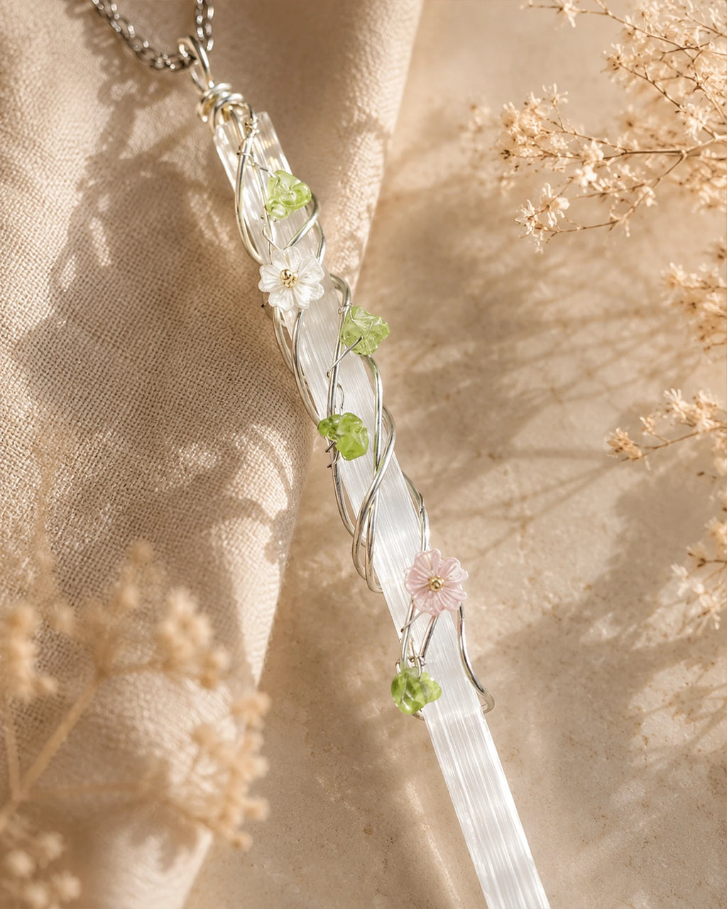 Close-up of handmade selenite garden wire wrapped pendant showing natural crystal texture, delicate wire wrapping, and floral accent details.