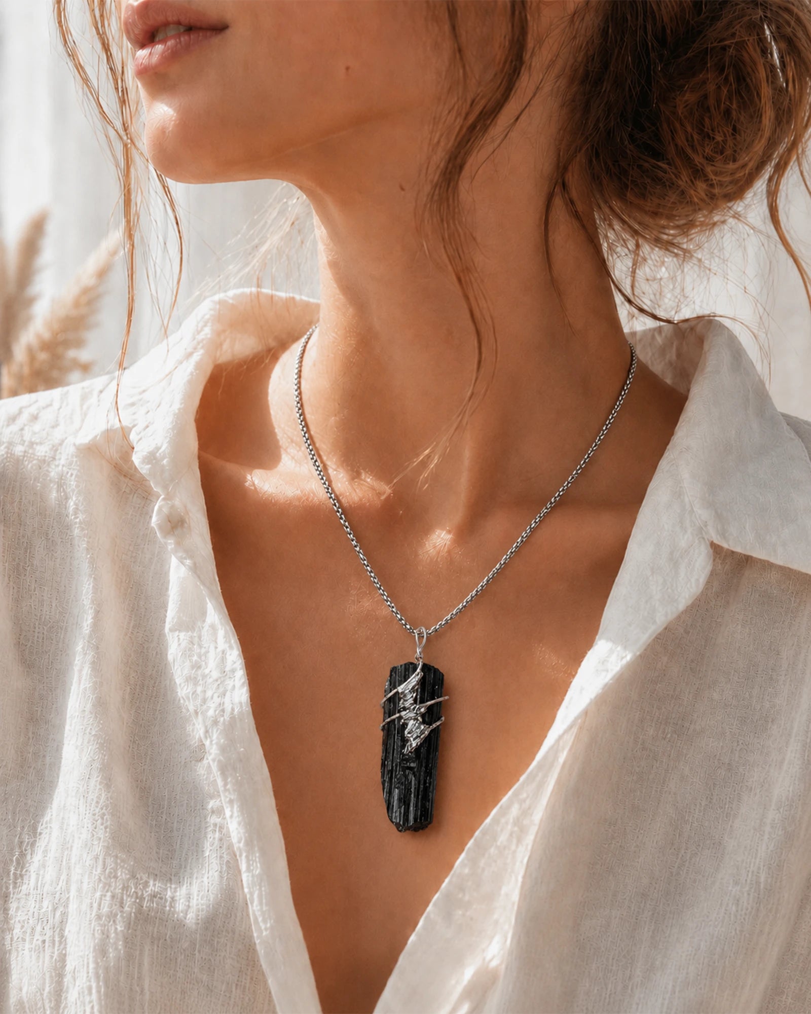 Woman wearing a handmade black tourmaline soldered pendant necklace, styled as meaningful crystal jewelry for protection and grounding.