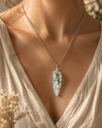 Woman wearing a handmade green crystal soldered pendant necklace, styled as meaningful crystal jewelry for growth, renewal, and abundance.