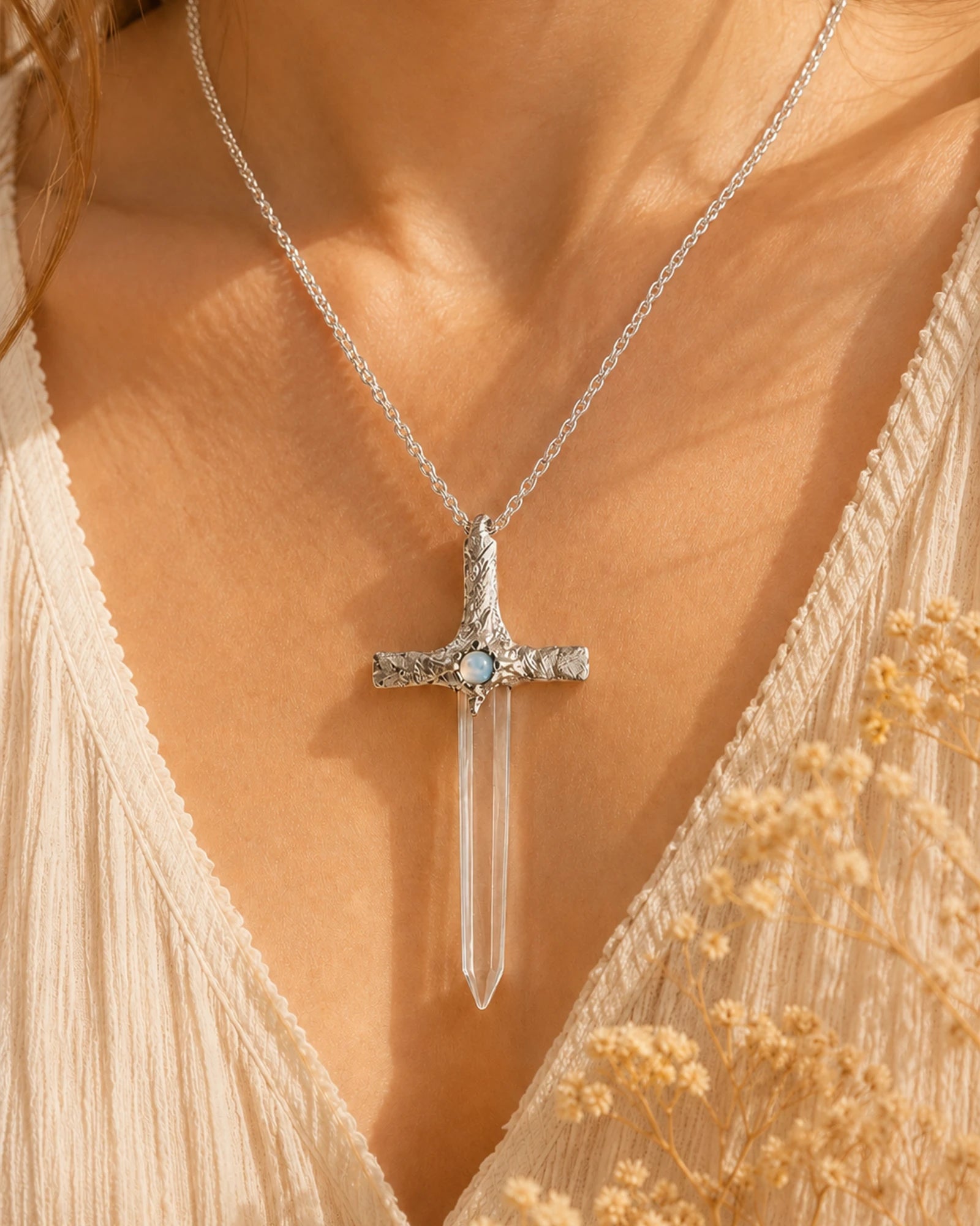 Woman wearing a handmade Lemurian quartz sword pendant necklace, styled as meaningful crystal jewelry for clarity and inner strength.