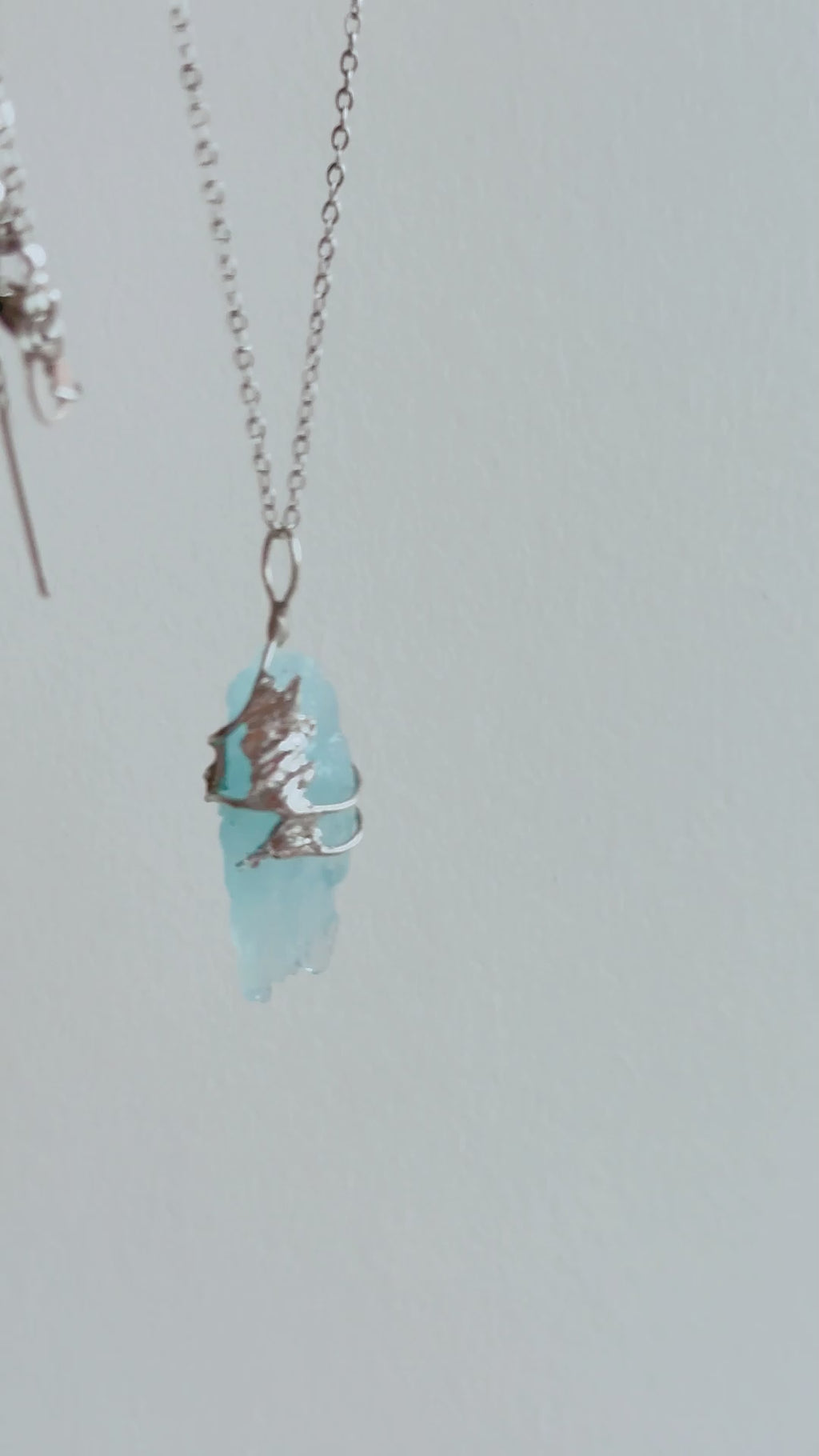 Packing video of a handmade Glacial Blue Crystal Necklace, showing the one-of-a-kind crystal pendant placed in a green gift box with ribbon and gift-ready packaging.