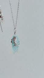 Packing video of a handmade Glacial Blue Crystal Necklace, showing the one-of-a-kind crystal pendant placed in a green gift box with ribbon and gift-ready packaging.