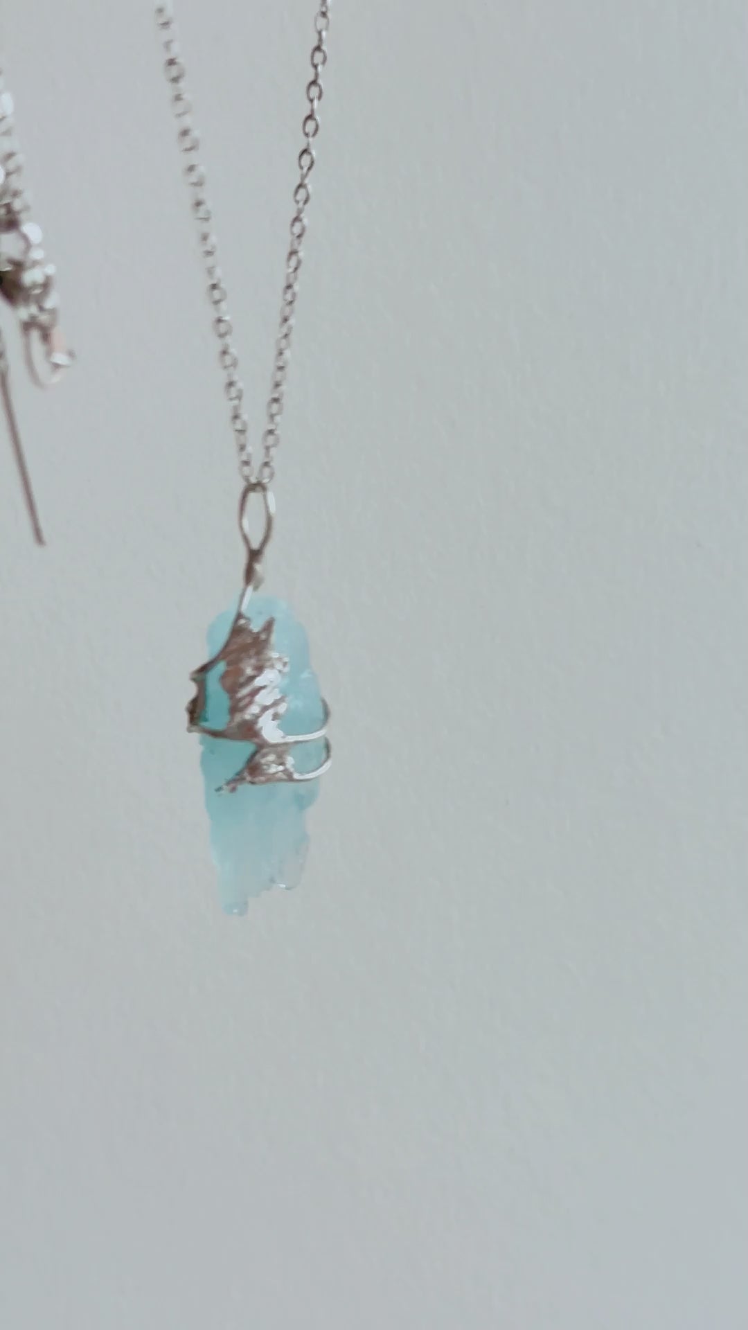 Packing video of a handmade Glacial Blue Crystal Necklace, showing the one-of-a-kind crystal pendant placed in a green gift box with ribbon and gift-ready packaging.